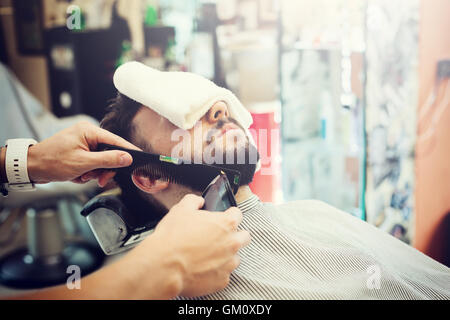 Traditional ritual of shaving the beard in a old style barber shop. Stock Photo