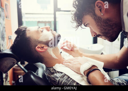 Traditional ritual of shaving the beard in a old style barber shop. Stock Photo