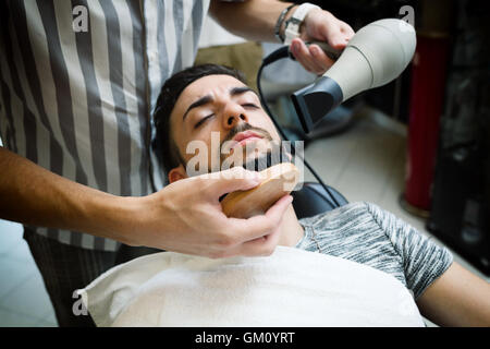 Traditional ritual of shaving the beard in a old style barber shop. Stock Photo