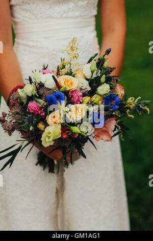 bride holding a bouquet of fresh wildflowers. Stock Photo
