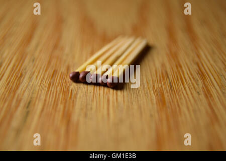 five matches lying on table in a line, close up Stock Photo