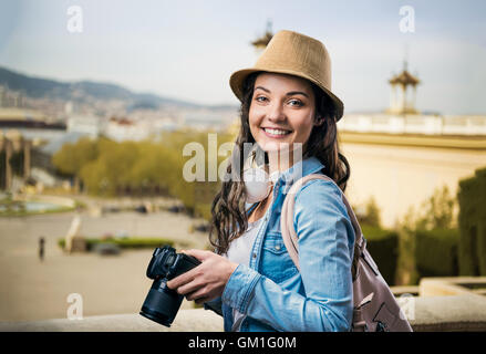 Tourist girl in denim shirt with camera, sunny city Stock Photo