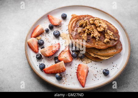 Fresh blueberry pancakes with honey, strawberries, blueberries, walnuts and chia seeds Stock Photo