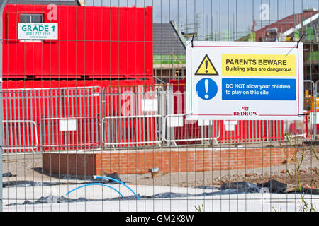 Parents Beware  Do not let your children play on this site Signs on Redrow Building Site in Chorley, Lancashire, UK Stock Photo