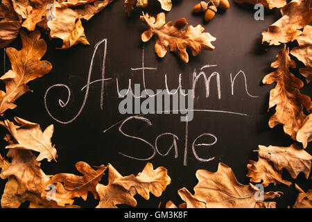 yellow leaves and the words autumn sale on a blackboard vintage style. Stock Photo