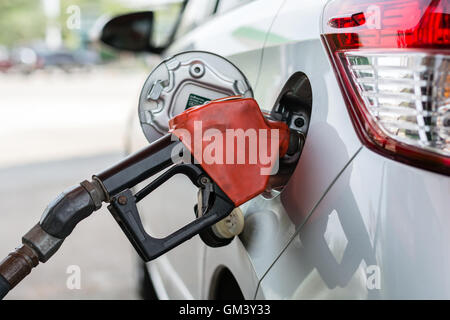 Fuel nozzle to add fuel in car at gas station Stock Photo