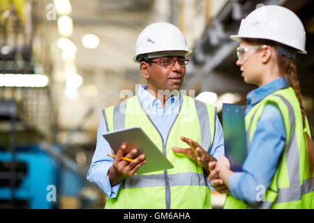 Two engineers discussing work and using tablet pc Stock Photo