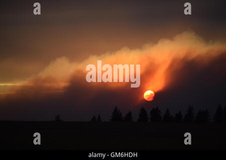 Sun setting through smoke. Stock Photo