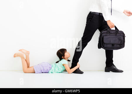 little girl holding her father's legs before go to work Stock Photo