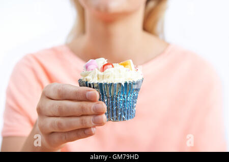 Close Up Of Woman Holding Unhealthy Cupcake Stock Photo