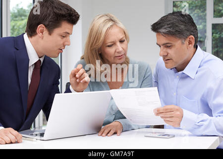 Mature Couple Meeting With Financial Advisor At Home Stock Photo