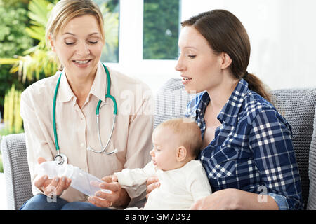 Health Visitor Giving Mother Advice On Feeding Baby With Bottle Stock Photo