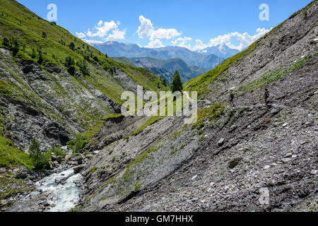 People trekking in the Valley Ferrand beside the Ferrand river, Oisans, France, Europe. Stock Photo