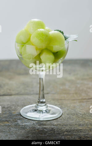 Fresh green cantaloupe melon in glass on wooden background Stock Photo
