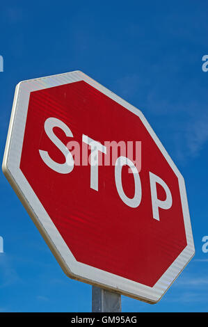 French red STOP sign against a blue sky Stock Photo