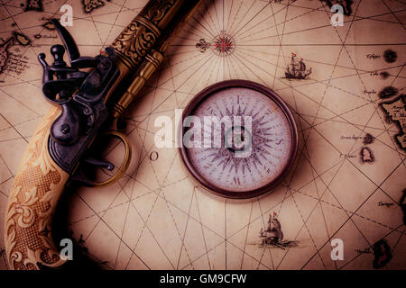 Compass And Pistole On Old Map Stock Photo