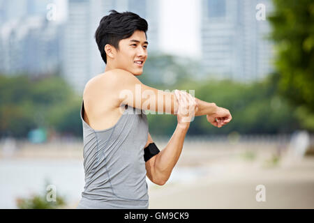 young asian man warming up by stretching arms before exercise. Stock Photo