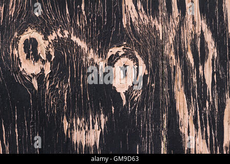 Photo of background texture with flaky old black paint over pink painted wood Stock Photo