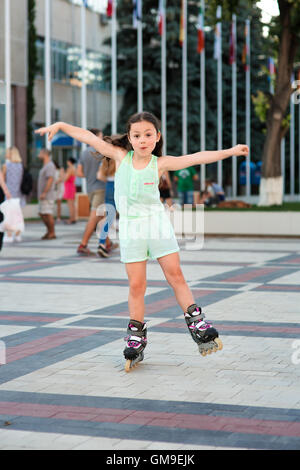 Little pretty girl on roller skates at a park Stock Photo