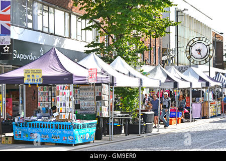 Brentwood Essex England UK High Street shopping and stall holders amongst various market stalls with town clock beyond sunny summer market day Stock Photo