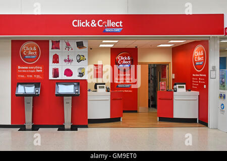 UK Tesco customer service in store Click and Collect counter using online internet browsing and provides customers online shopping ordering facility Stock Photo
