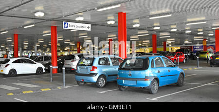 Tesco supermarket indoor ground floor under cover car park below first floor shopping deck Chesterfield Derbyshire England UK (few blanked car numbers Stock Photo