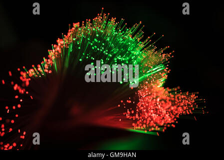 Bunch of glowing red and green fiber optic cables on black background Stock Photo