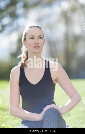 Mid-adult woman exercising in park Stock Photo