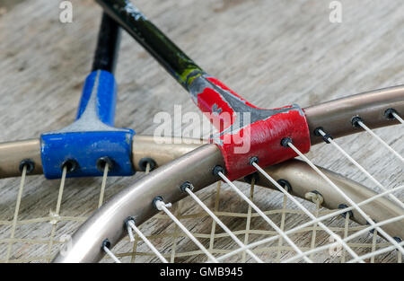Old badminton racket on wooden background in close up view. Stock Photo