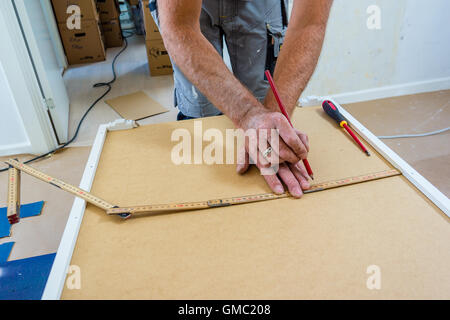 carpenter mounting IKEA kitchen Stock Photo