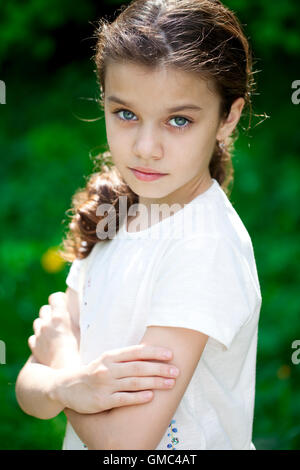 Portrait of a beautiful young little girl on the background of summer park Stock Photo