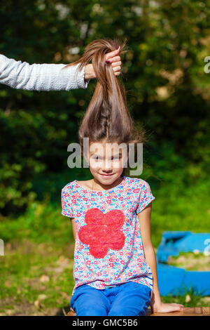 Hair Up. Close up portrait of a beautiful nine year old little girl in autumn park Stock Photo