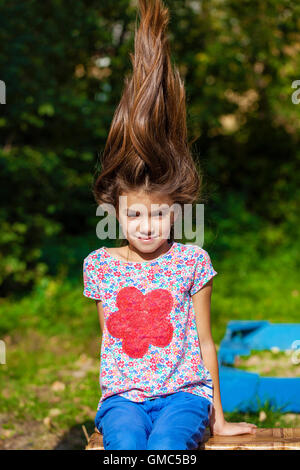 Hair Up. Close up portrait of a beautiful nine year old little girl in autumn park Stock Photo
