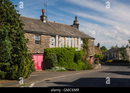 Country lane bends round traditional, stone-built, Yorkshire Dales cottages -  Austwick village, North Yorkshire, England. Stock Photo