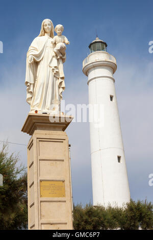 Statue of Mary holding Jesus, and the lighthouse, Punta Secca, Santa Croce Camerina, Sicily, Italy Stock Photo