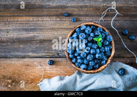 Freshly picked blueberries in a bowl on wooden background with copy space Stock Photo