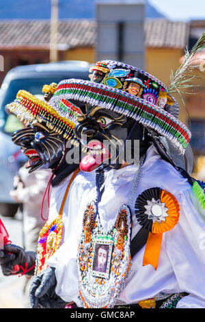 Ollantaytambo, Peru - May 16 : Religious celebration for Fiestas de Pentecostes with people wearing masks and colorful clothing Stock Photo