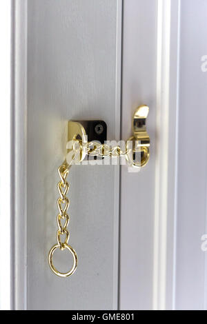 Safety chain in use on front door England UK Stock Photo
