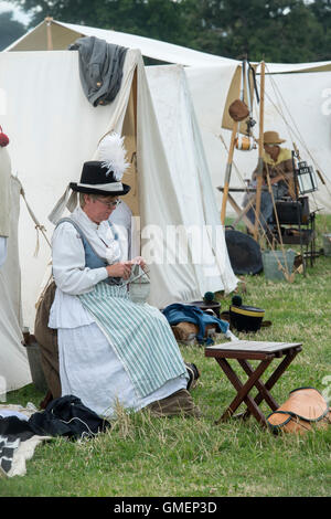 21st eme Regiment de Ligne woman knitting in a camp. Napoleonic war reenactment at Spetchley Park, Worcestershire, England Stock Photo