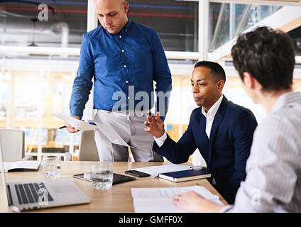 Three diverse, well dressed, eclectic entrepreneurs working in collaboration Stock Photo