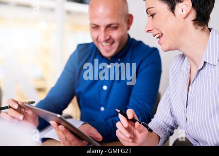 businessman and businesswoman collaborating on their latest project using tablet Stock Photo