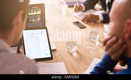 Graphic information being displayed on a tablet during business meeting Stock Photo