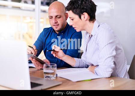business executives collaborating together using technology to make progress Stock Photo