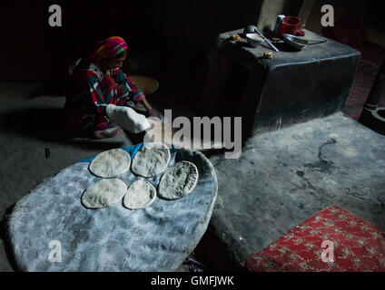 Afghan woman making bread inside her traditional pamiri house, Badakhshan province, Khandood, Afghanistan Stock Photo