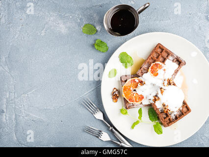 Belgian soft waffles with blood orange, cream, marple syrup and mint  on white plates Stock Photo