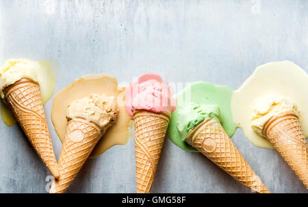 Colorful ice cream cones of different flavors. Melting scoops. Top view,  steel metal background Stock Photo