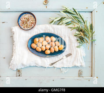 Green big olives in rustic ceramic plate with tree branch and spices Stock Photo