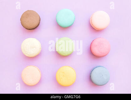 Sweet colorful French macaroon biscuits on pastel lilac background Stock Photo