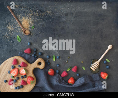 Berry frame with copy space on right. Strawberries, raspberries, blueberries and mint leaves Stock Photo