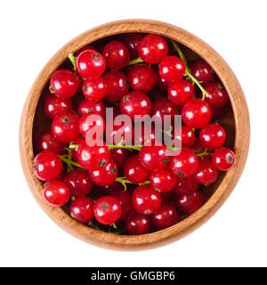 Redcurrant berries in a wooden bowl on white background, also called red currant. Ripe fruits of Ribes rubrum, gooseberries. Stock Photo